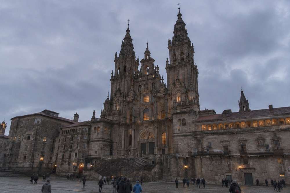 The Cathedral towers of Santiago de Compostela lit at dusk above the old town rooftops